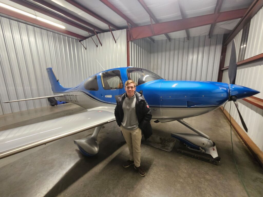 Mechanical engineering student Andrew Chapin standing in front of a private plane.